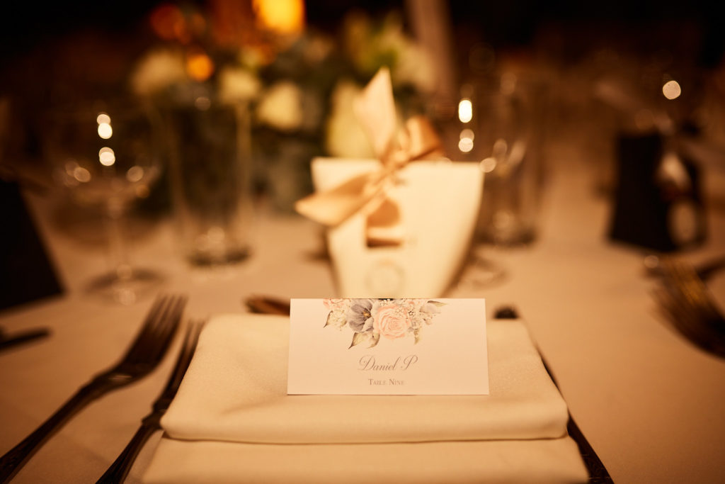 Place setting with a folded napkin and name card in candlelight