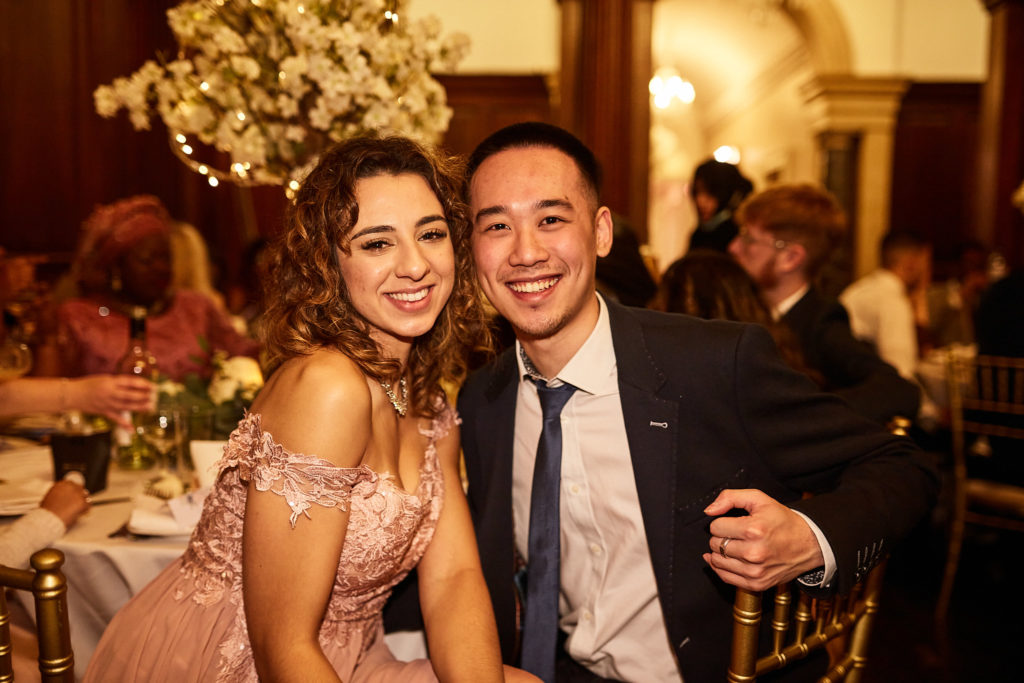 Two wedding guests smiling at the camera at their table