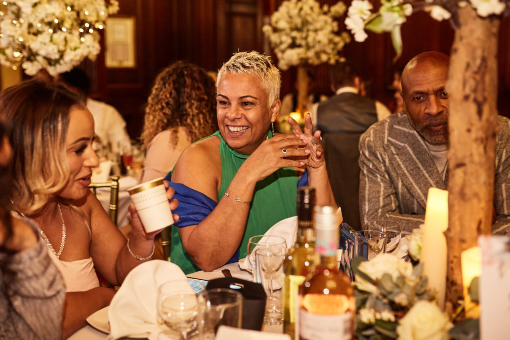 Wedding guests laughing at the table during the wedding breakfast