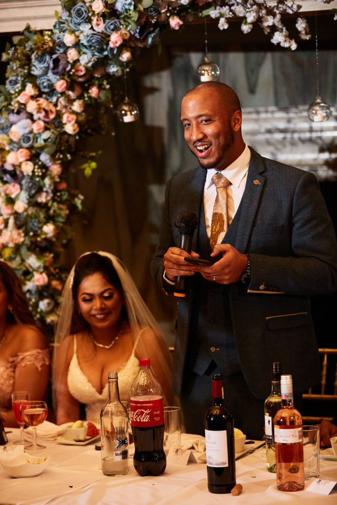 Groom giving his speech as the bride looks up at him