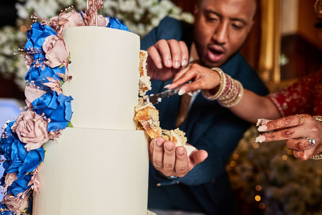Close-up of the groom feeding the bride a piece of wedding cake