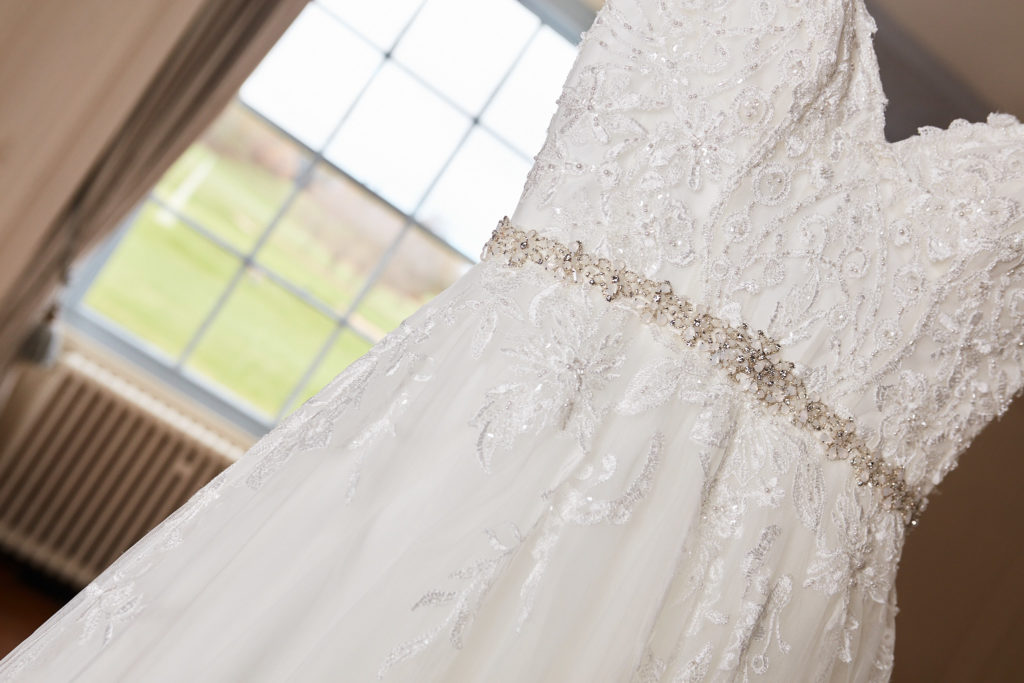 Close-up of the lace bodice and beaded belt of the wedding dress