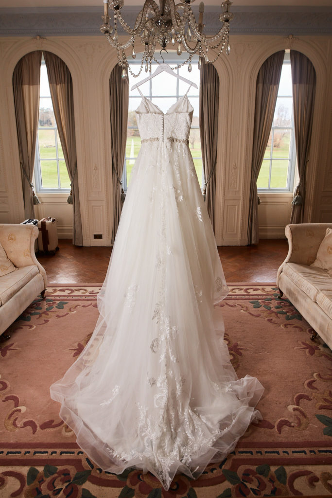 Back of the wedding dress and its long train hanging in the bridal suite