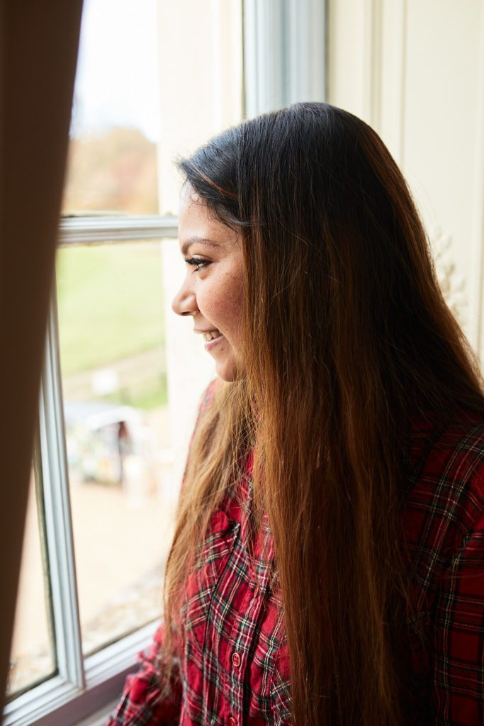 Bride looking out of a window on the wedding morning