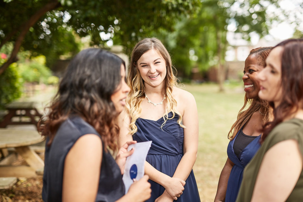 Bridesmaids in navy dresses chatting in the garden