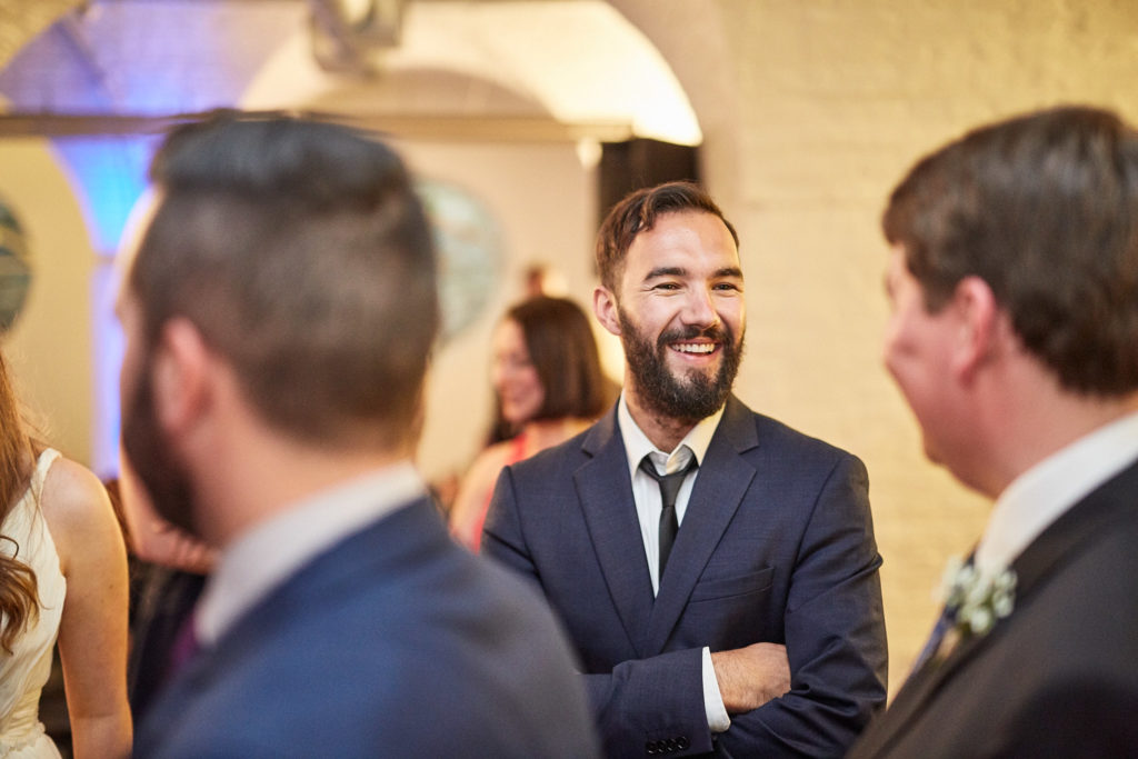Wedding guests laughing together at the evening reception