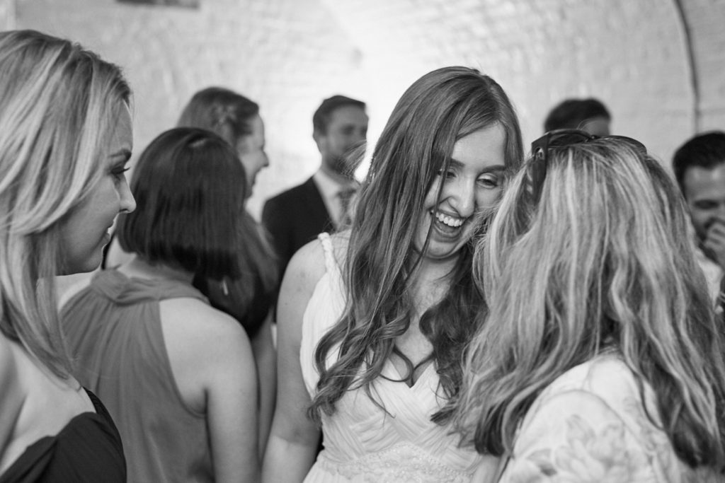 Black and white photo of guests laughing on the dance floor