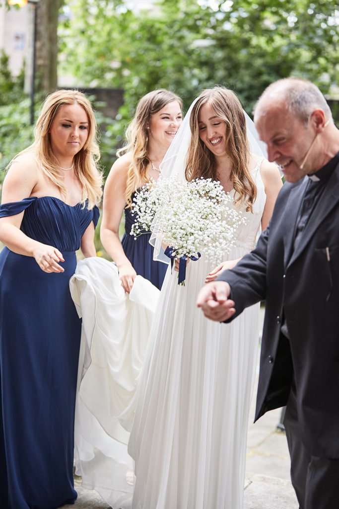 Vicar greeting the bride and her bridesmaids as she arrives at the church