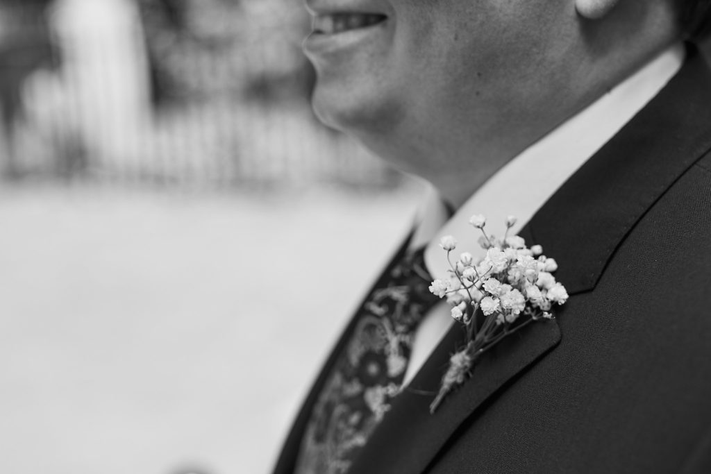 Black and white close-up of the groom's gypsophila buttonhole