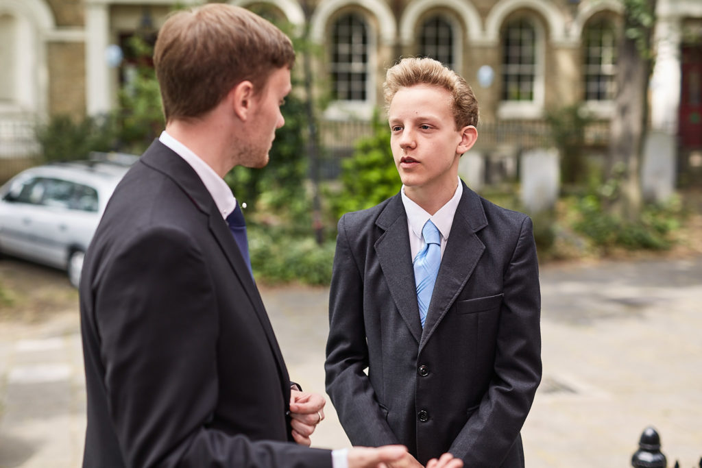Two groomsmen chatting outside the church