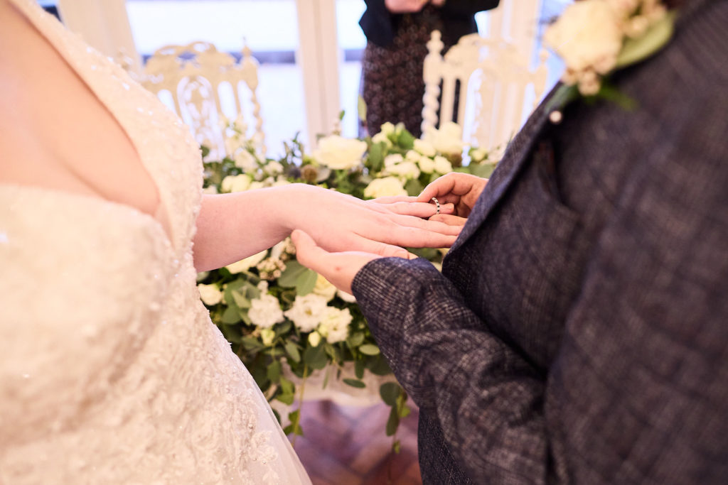 Close-up of a wedding ring being placed on a finger during the ceremony