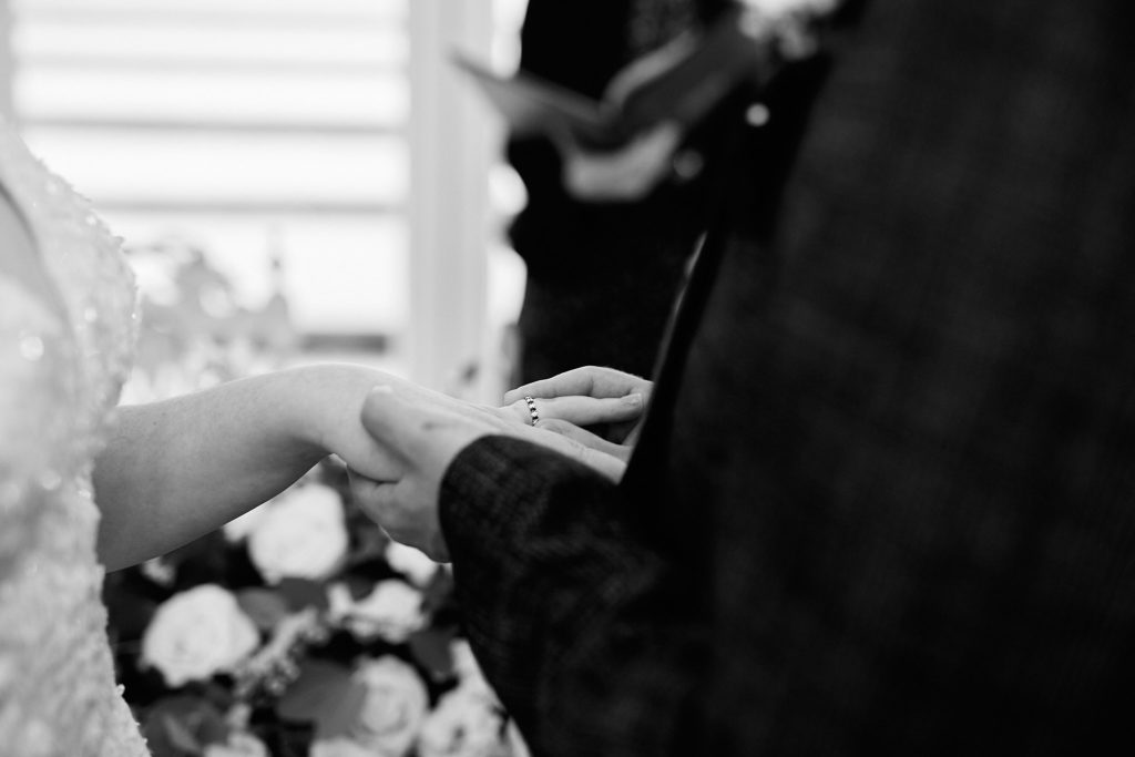 Black and white close-up of the bride and groom exchanging rings