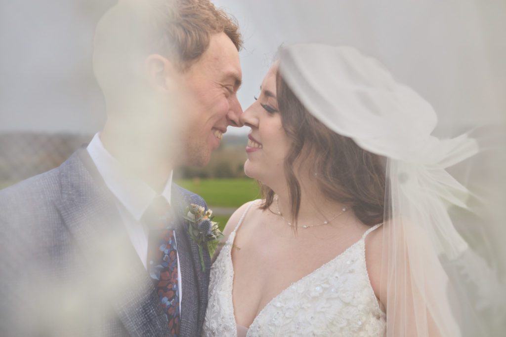Bride and groom nose to nose at Crondon Park, photographed through the soft haze of the veil