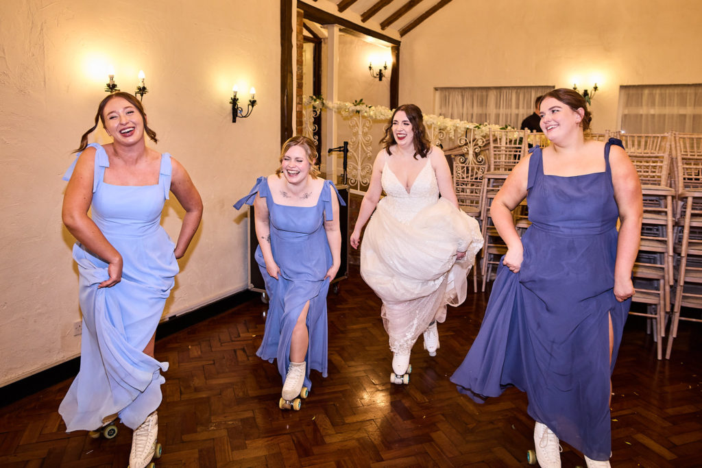 Bride and bridesmaids roller skating across the dance floor, laughing
