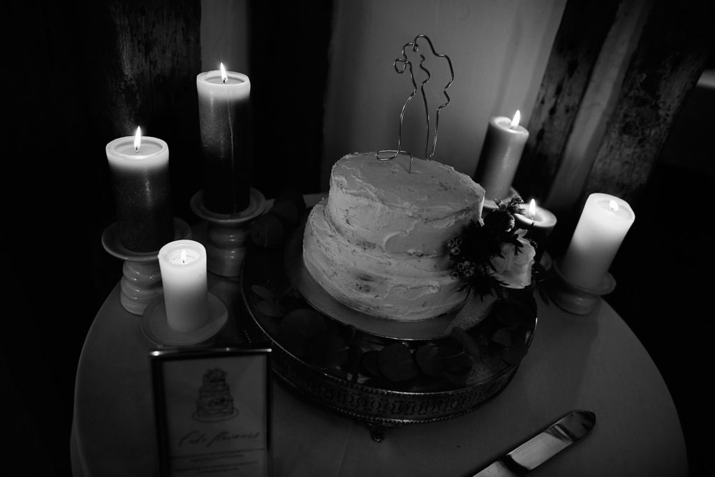 Black and white photo of the wedding cake surrounded by candles