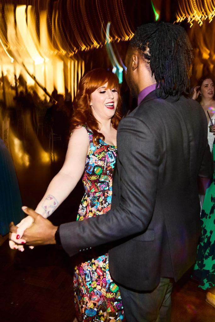 Wedding guests dancing together in the barn