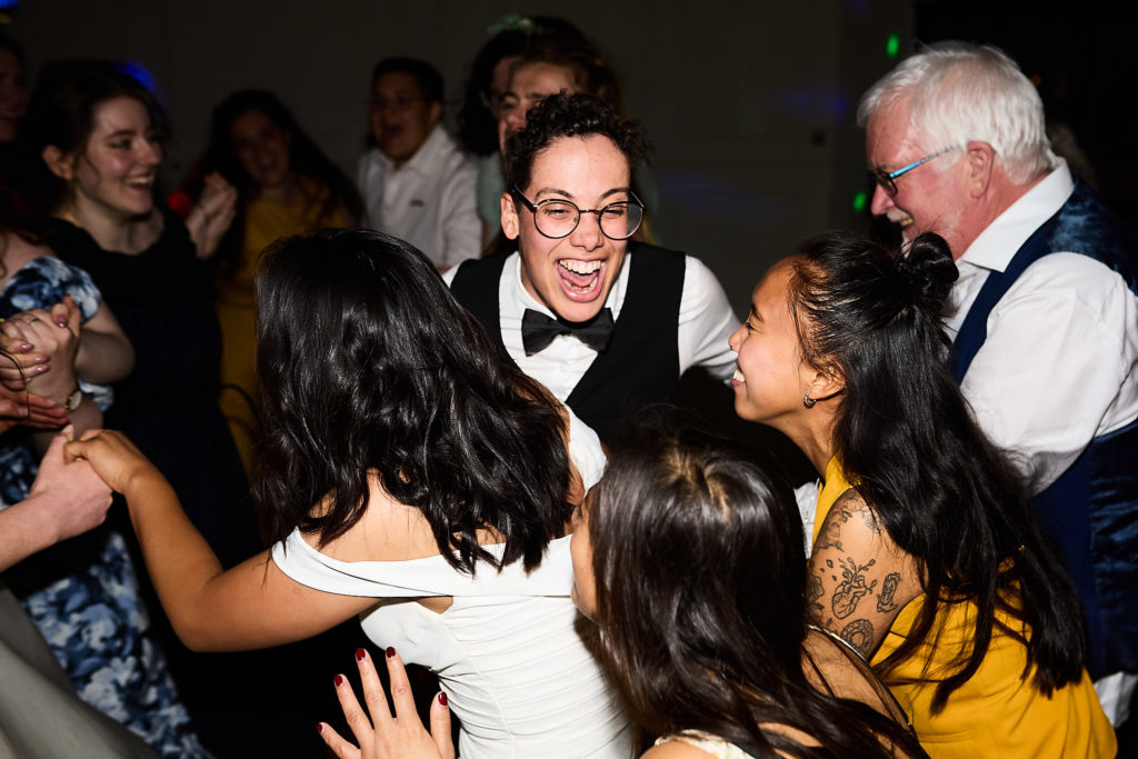 Wedding guests crowding round and laughing on the dance floor