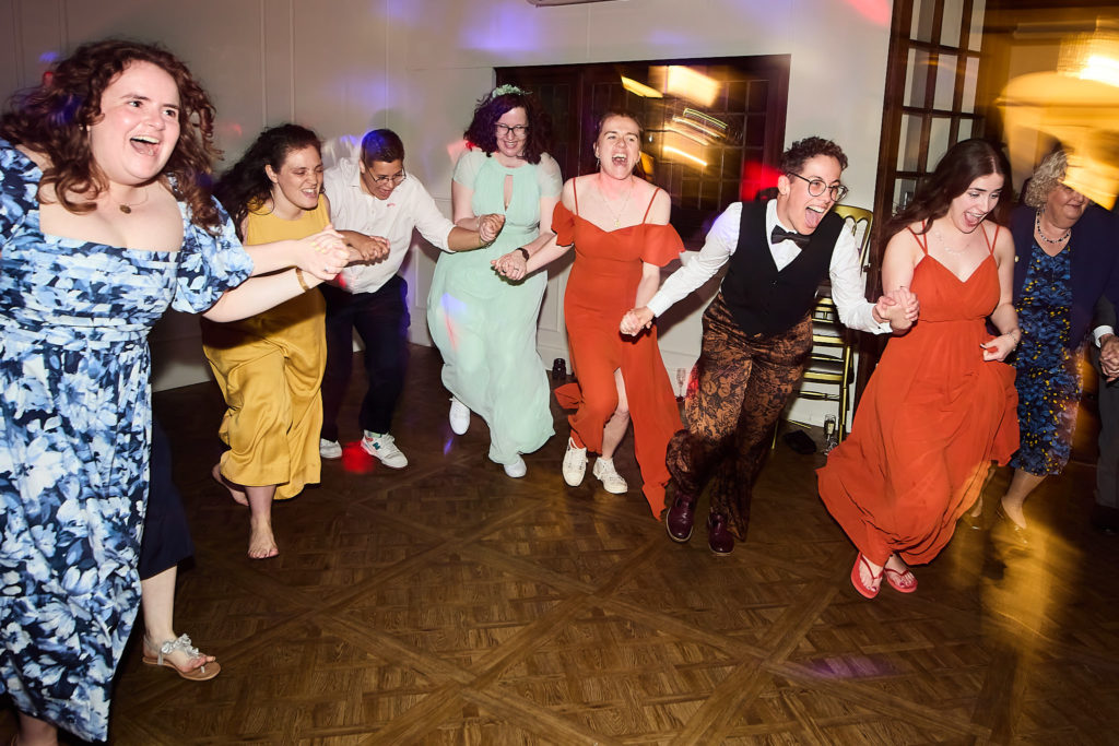 Wedding guests dancing in a line across the dance floor