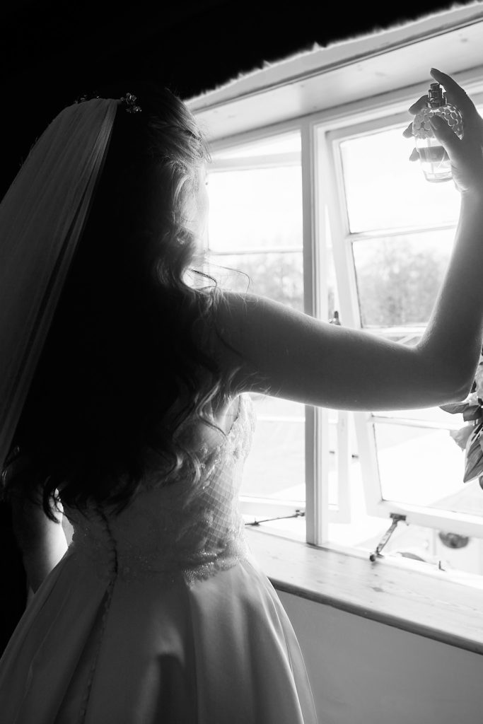 Black and white silhouette of a bride at a window