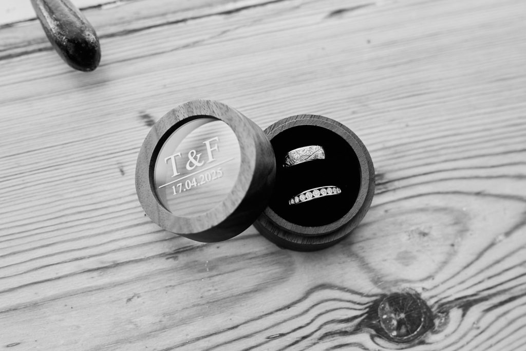 Black and white photo of wedding rings in a wooden ring box