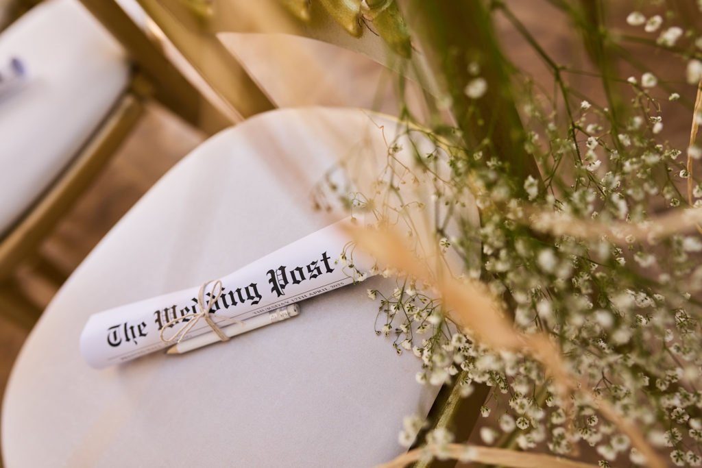 Rolled wedding newspaper tied with dried grasses on a chair