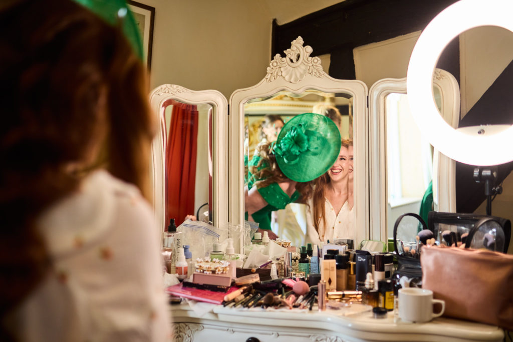 Bride getting ready at a dressing table covered in make-up