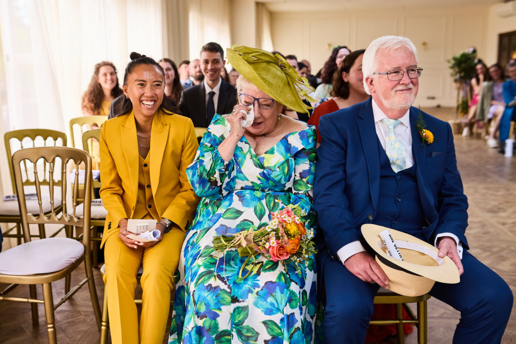 Guests in the front row wiping away tears and smiling during the ceremony
