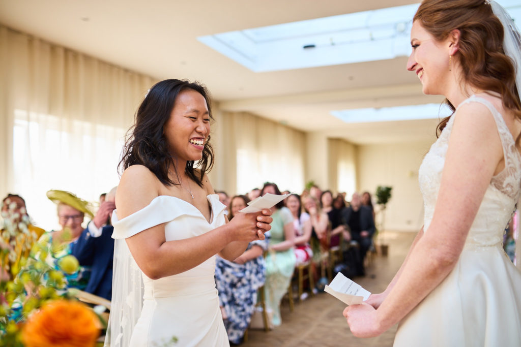 Bride laughing as she says her vows to her wife
