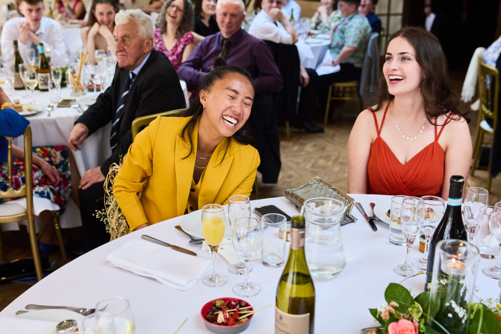 Wedding guests laughing at the table during the wedding breakfast