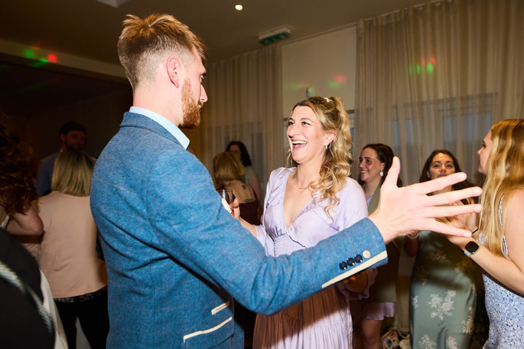 Guest in a blue jacket dancing with a woman in a lilac dress