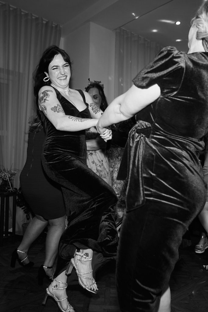 Black and white photo of two guests dancing hand in hand