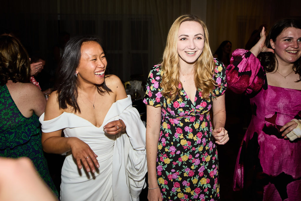Bride laughing with guests on the dance floor