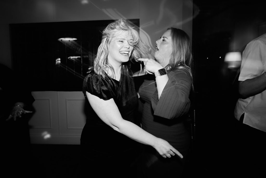 Black and white photo of two guests singing together on the dance floor