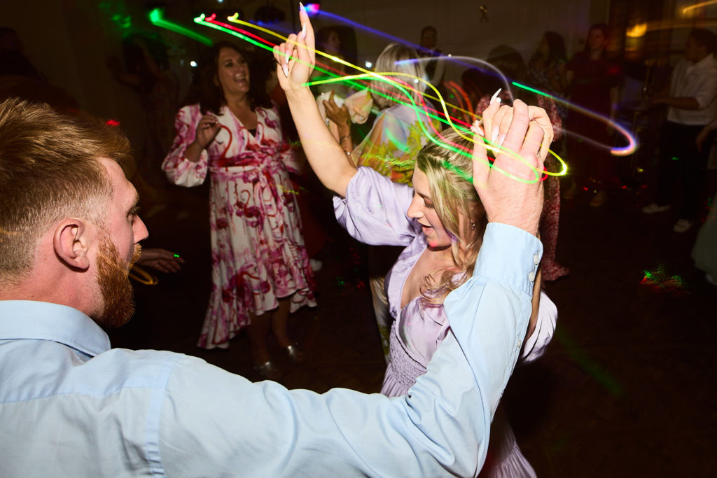 Wedding guests dancing with glow sticks