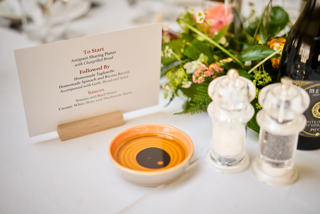 Menu card on the table beside salt and pepper grinders
