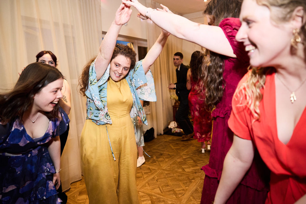 Wedding guests dancing under each other's raised arms
