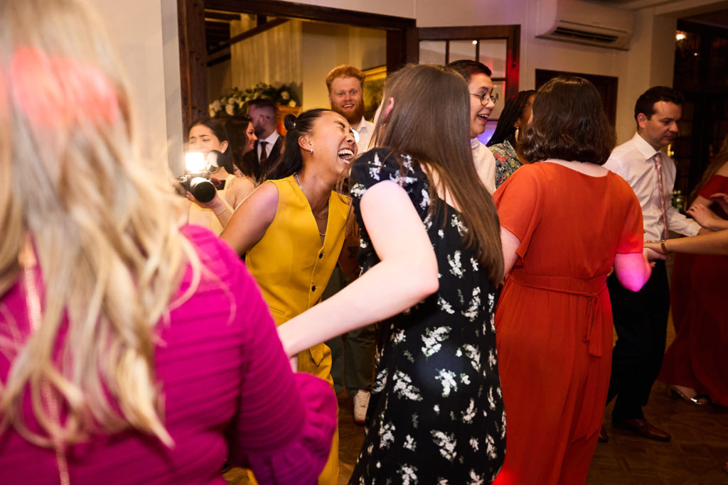 Wedding guests dancing in colourful outfits