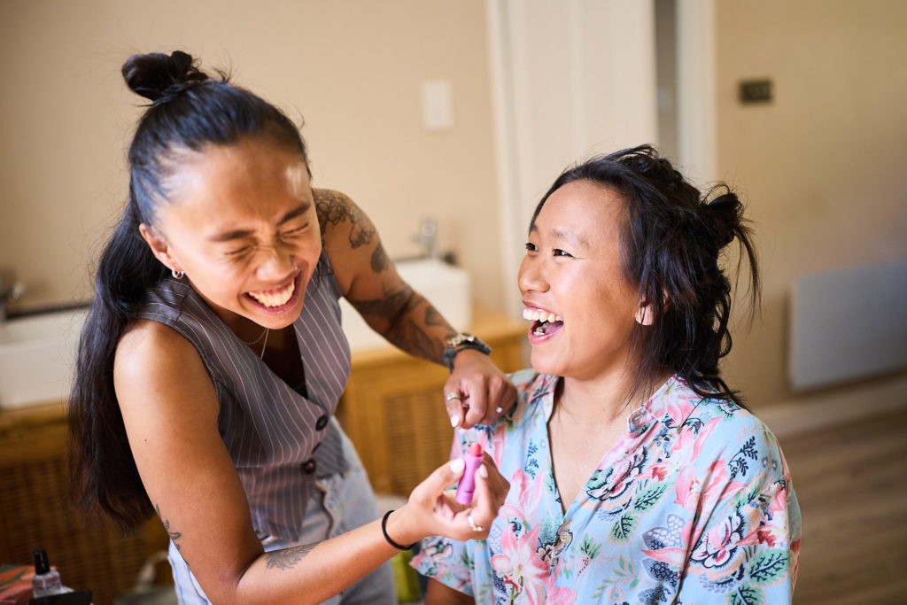 Bride laughing as she has her make-up done