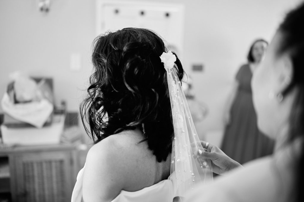 Black and white photo of a bride with flowers pinned in her hair