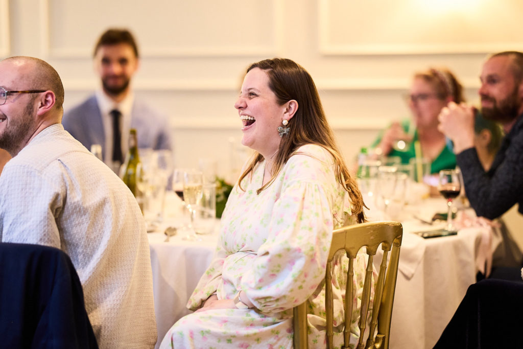 Wedding guest laughing at the table during the wedding breakfast