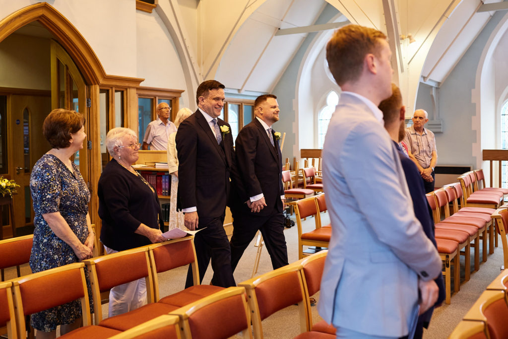 Two grooms arriving at the front of the church for their wedding ceremony