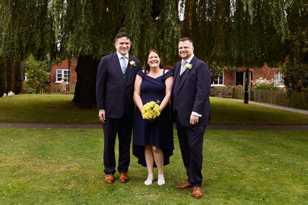 Two grooms with their best woman under a willow tree