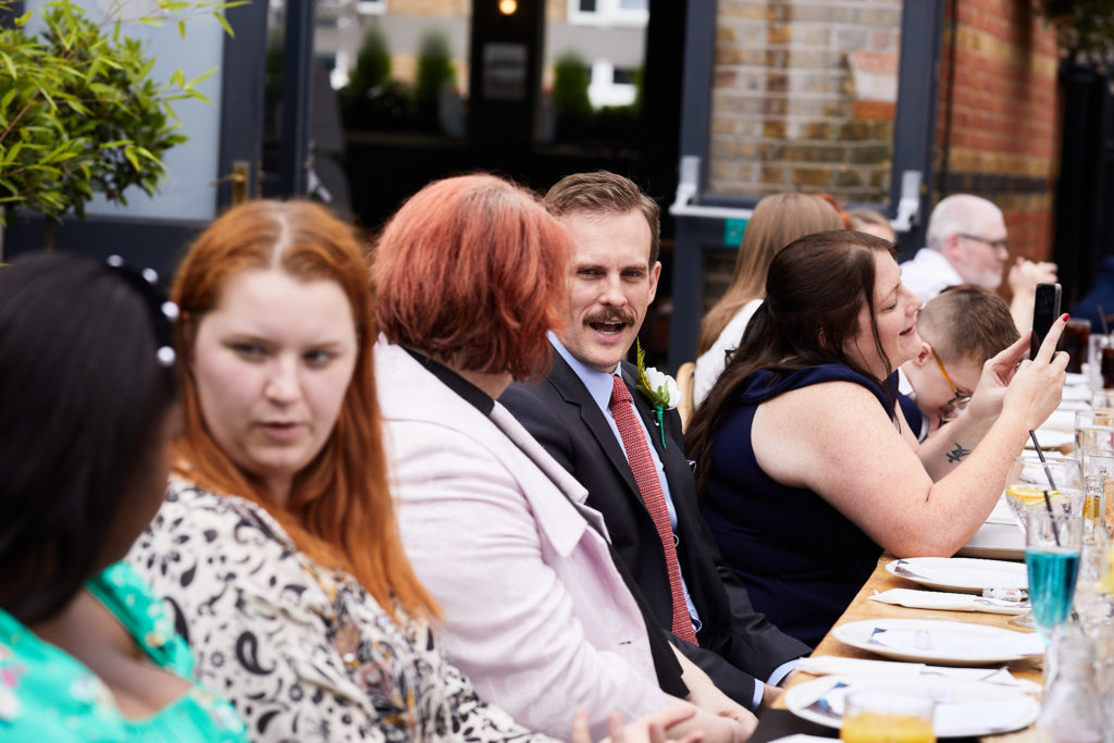 Wedding guests laughing at the table during the wedding breakfast