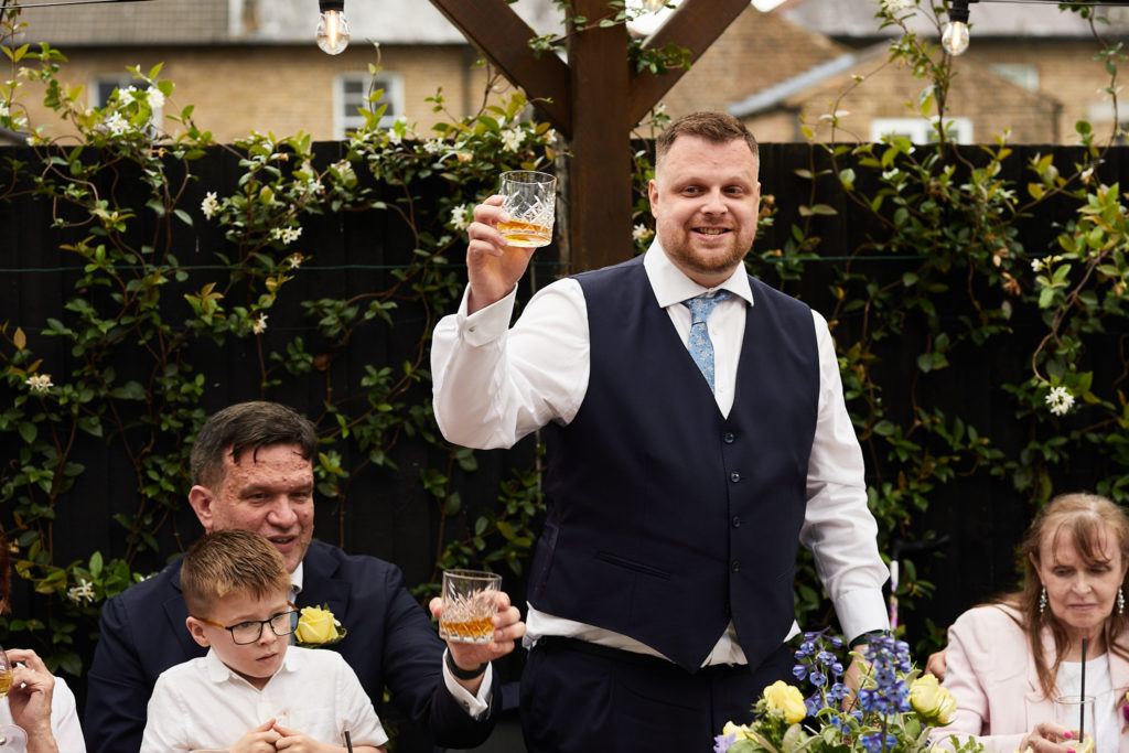 Groom raising a glass during his speech