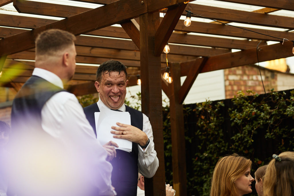 Groom laughing during the speeches under the pergola