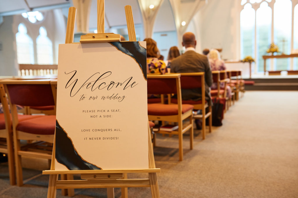 Wedding welcome sign on an easel inside the church