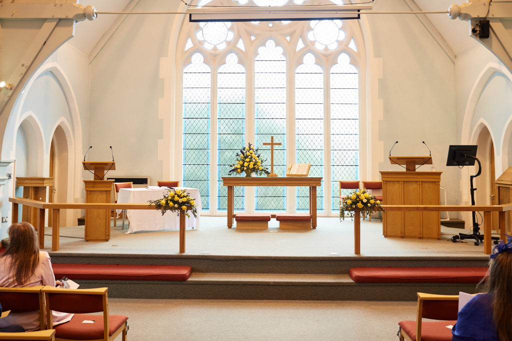 Church interior set for the wedding ceremony with yellow flowers on the altar