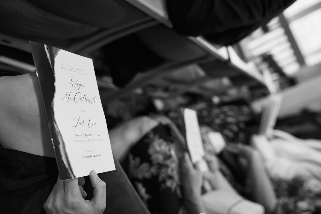 Black and white photo of a guest holding the order of service
