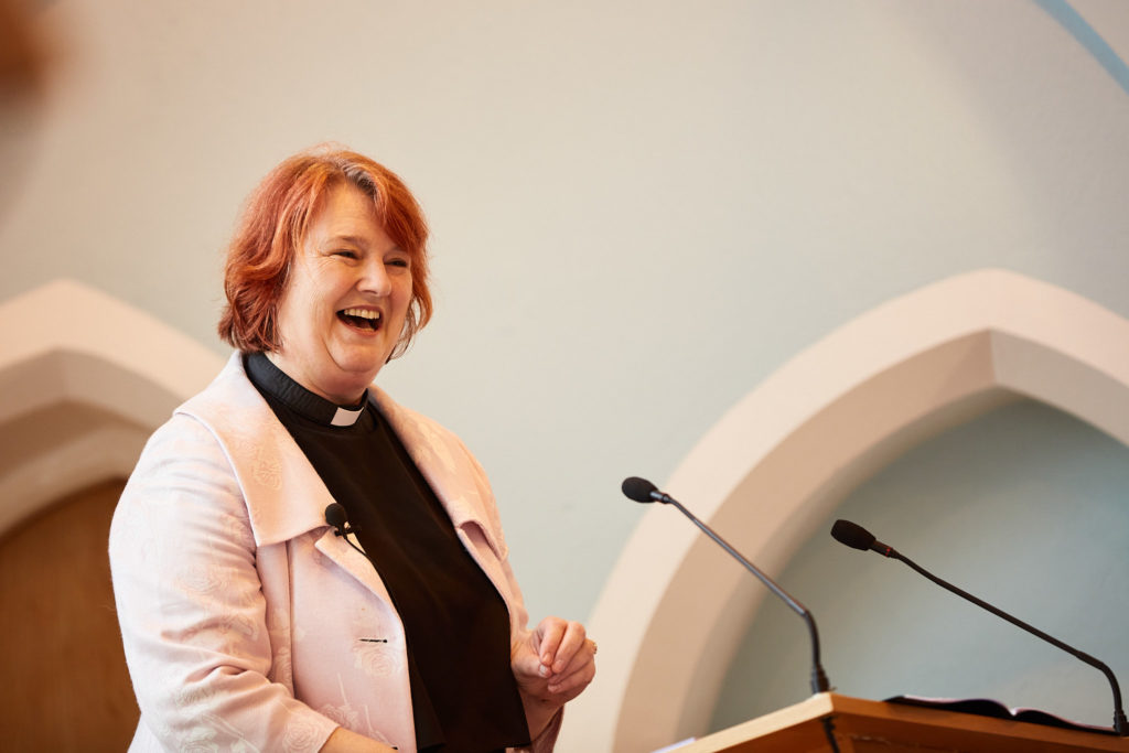Minister smiling as she leads the wedding ceremony