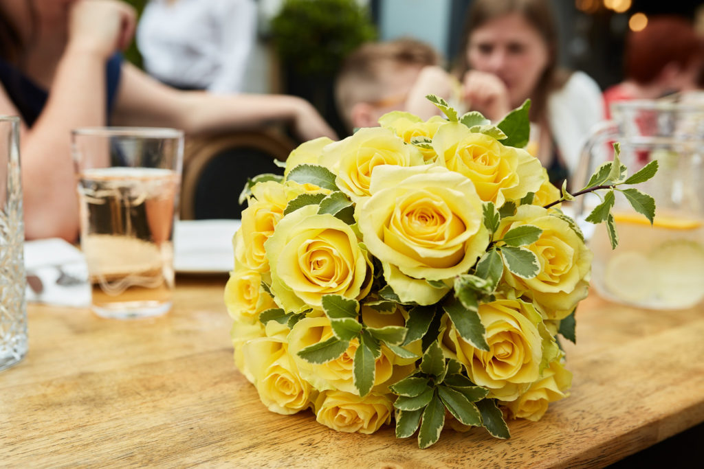 Bouquet of yellow roses on a wooden table